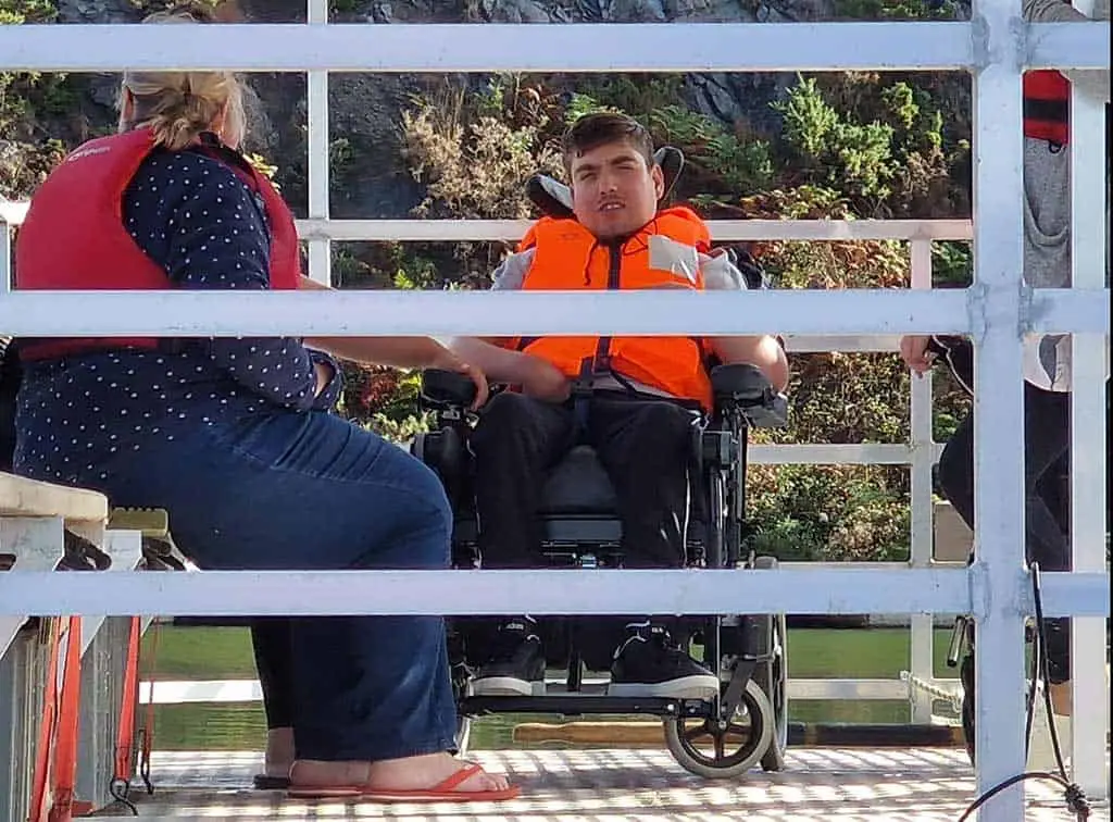 Wheelchair friendly watersports - a wheelchair user gets out on the water