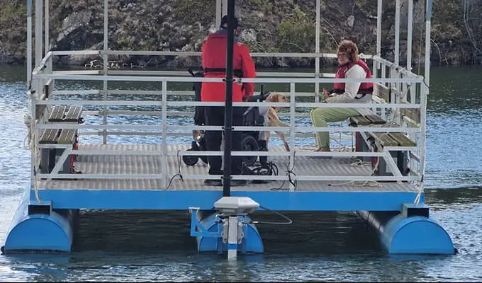 Wheelchair user David with his wife and dog aboard Floaty on Trevassack Lake