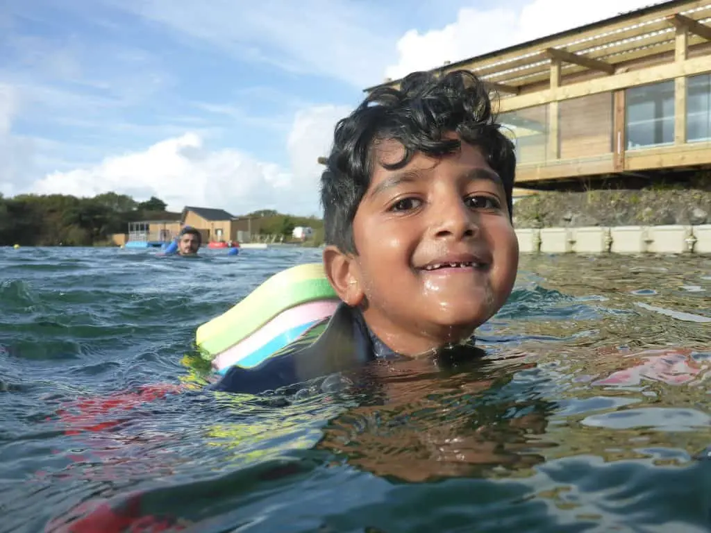 Young boy on holiday swims at Trevassack Lake