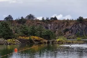 A picture of Trevassack Lake in Autumn with two swimmers in the distance